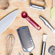 Various kitchen tools seen from above on wooden table